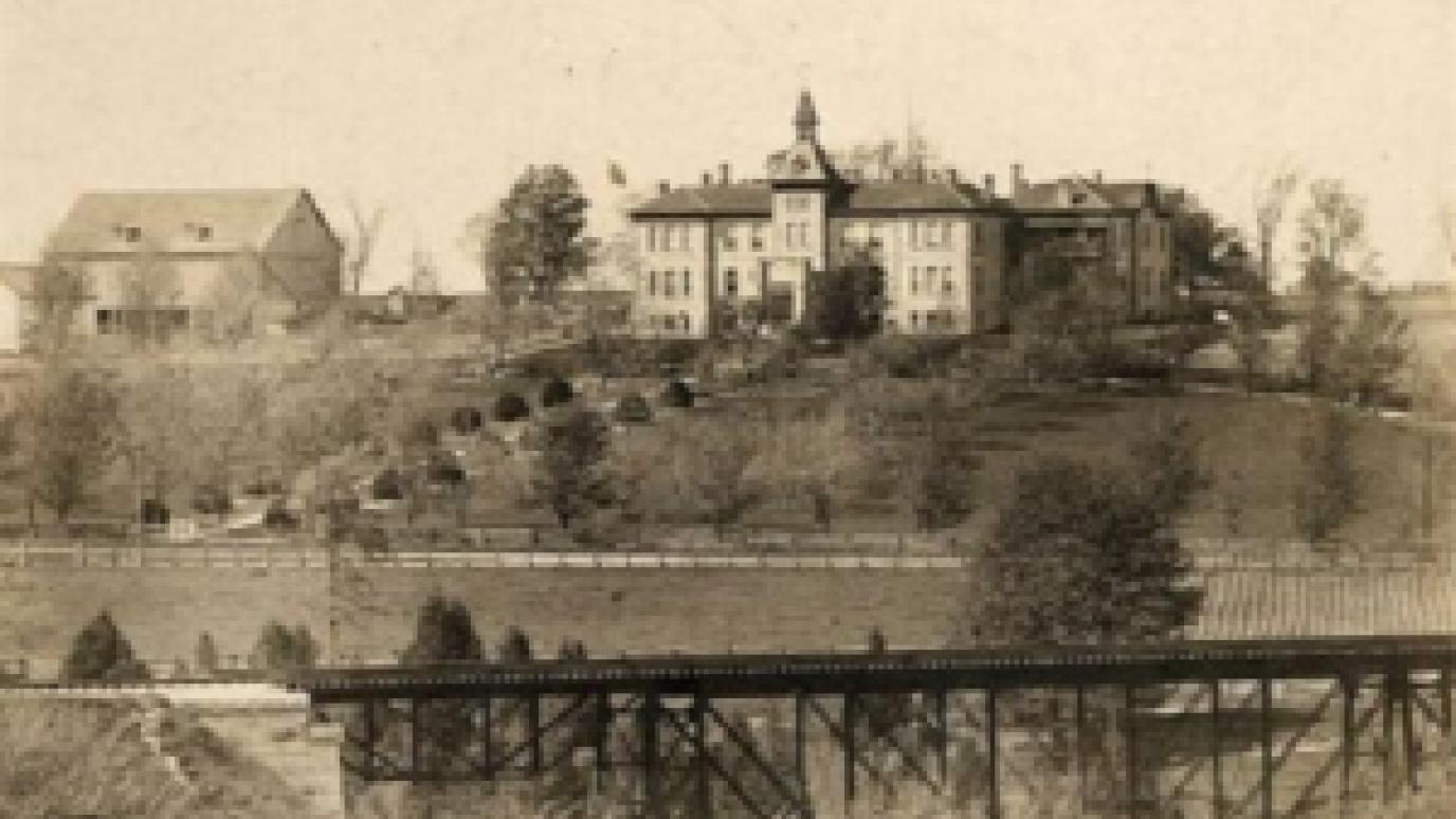 old photo of wellington county museum and archives with train tracks in front