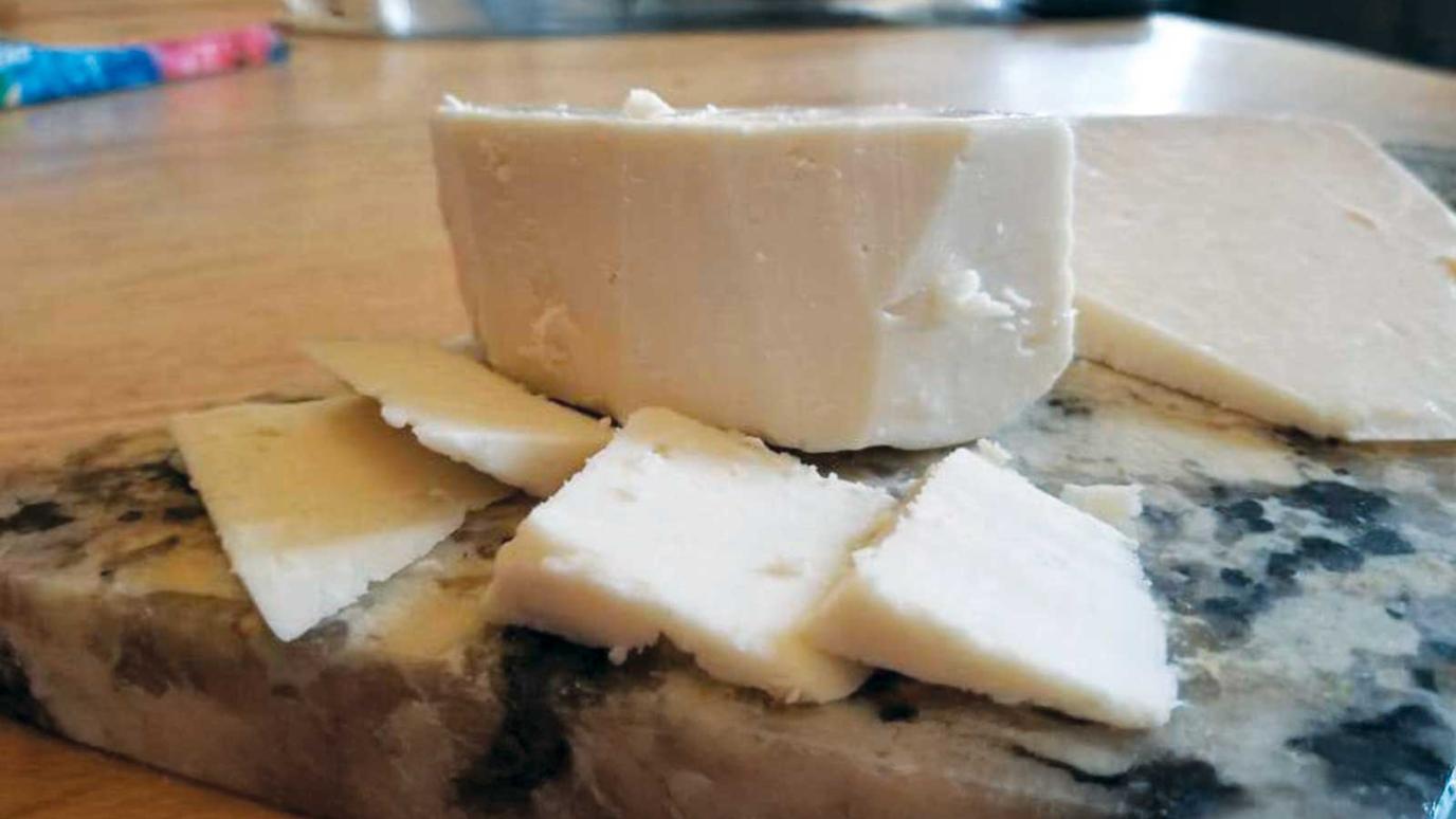 sliced white artisan cheese on marble stone