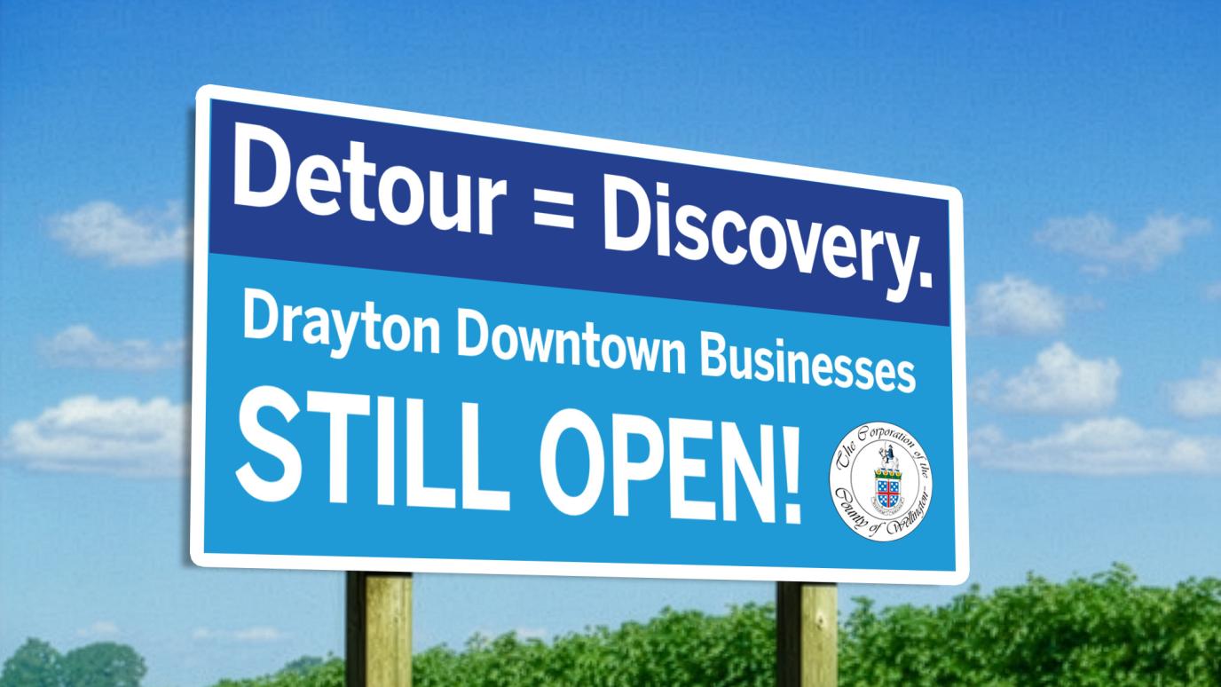 A highway sign that reads Detour=Discovery, Drayton Downtown Businesses STILL OPEN