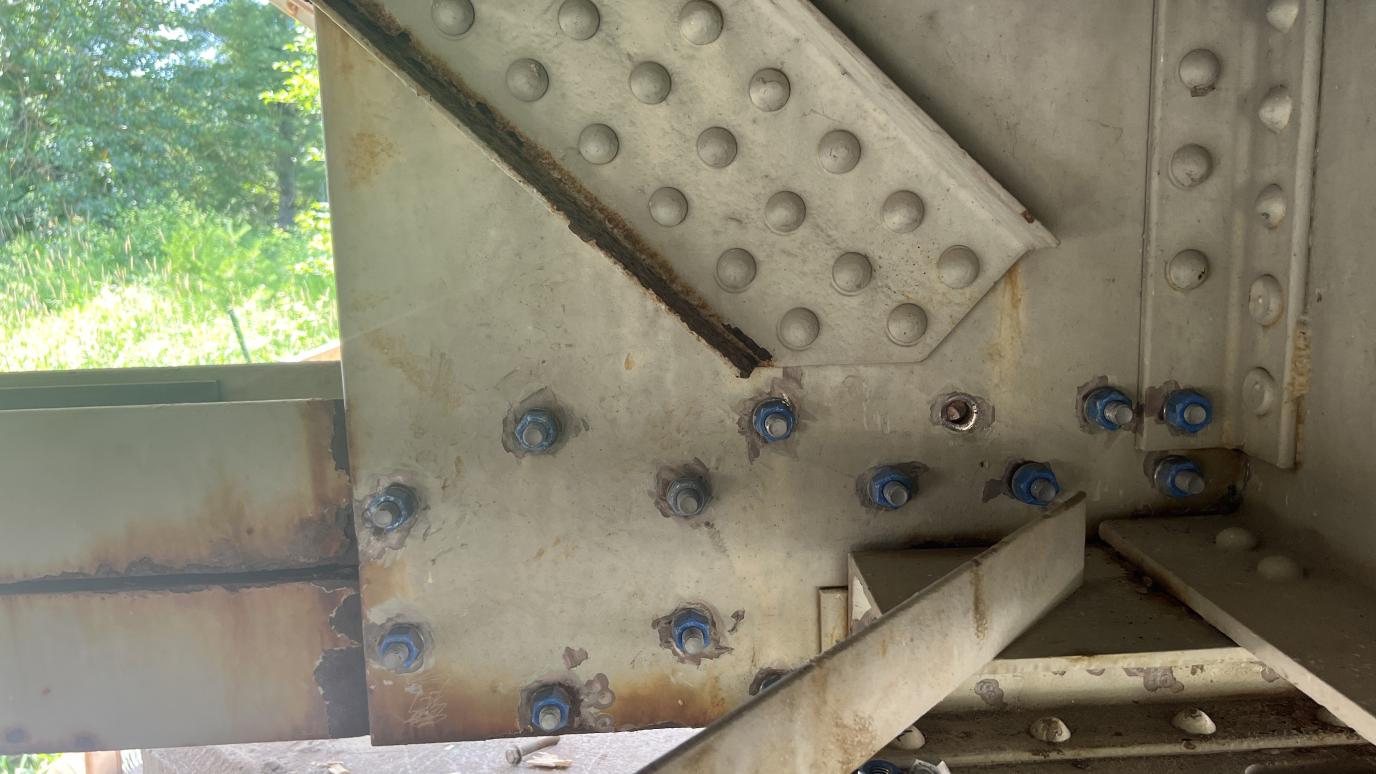 close up of old rivots and new bolts.
