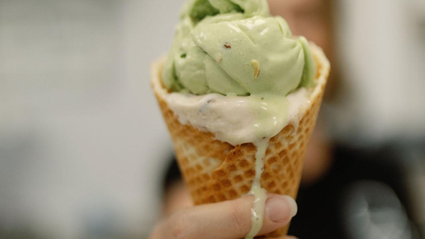 hand holding waffle cone filled with ice cream