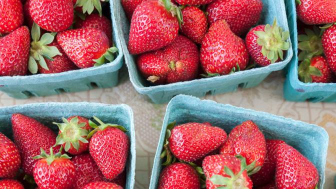 Baskets of strawberries at a market viewed from above