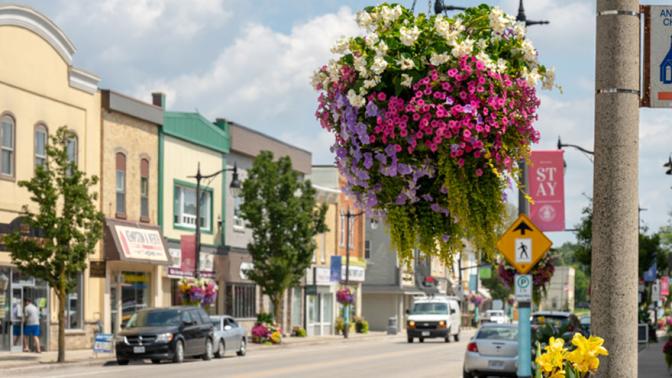 Hanging flower baskets decorate the lamp posts on a lovely rural downtown street
