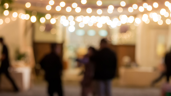 People walking around under fairy lights