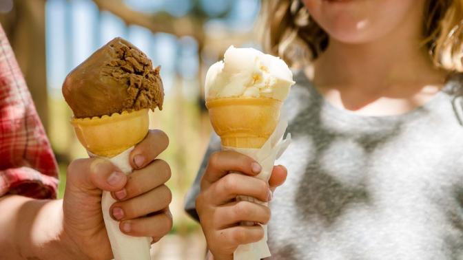 two hands holding ice cream cones
