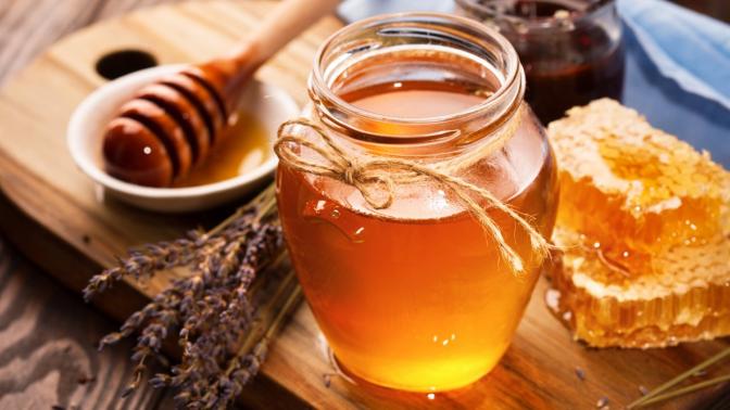 jar of honey and honeycomb on a table
