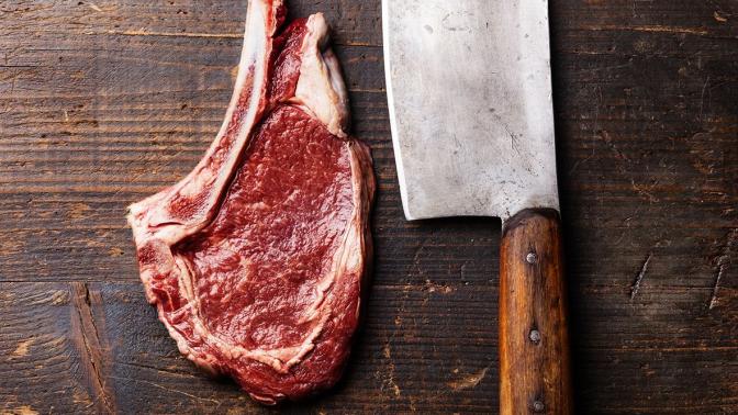 steak and butcher knife on a cutting board