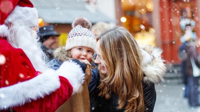 Santa visiting child with person during Christmas event