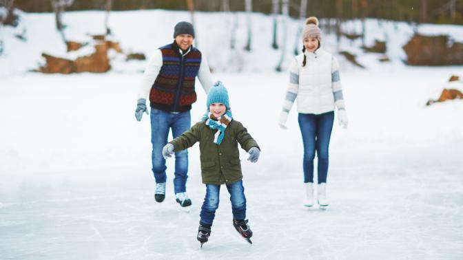 three people skating on ice