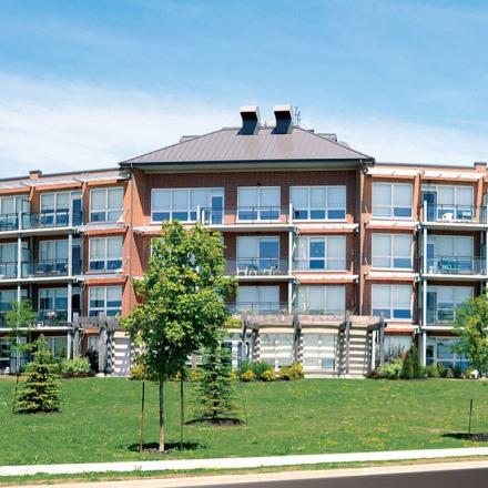 A condo building, several units wide, and about four stories tall.