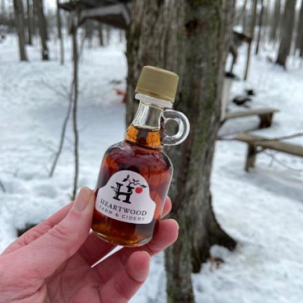 hand holding small bottle of maple syrup