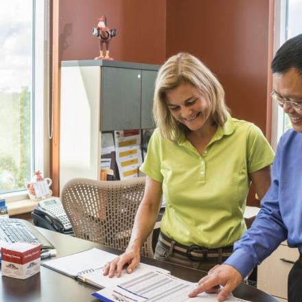 Woman and man discussing project in sunlit office