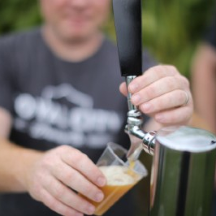 A person is filling a glass with beer