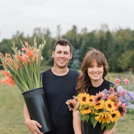 two people holding buckets of flowers