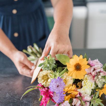 person tying bouquet of flowers