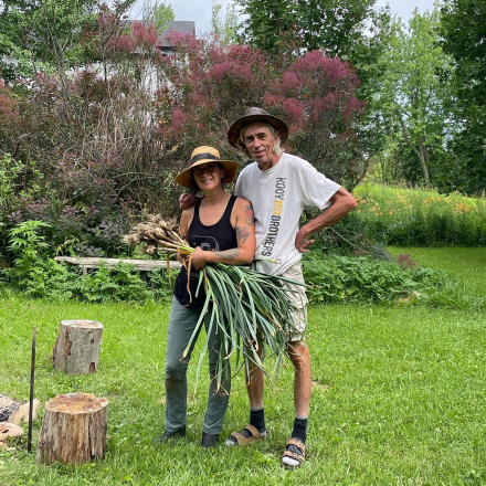 two people standing with vegetables