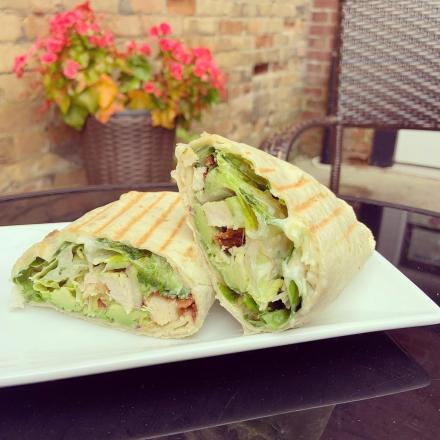 sandwich wrap on plate with lettuce, chicken and more