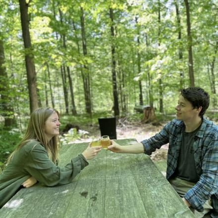 two people cheersing in a forest garden
