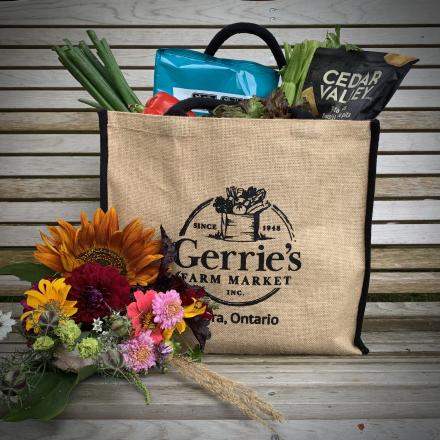 burlap grocery bag with local food products and fresh cut flowers
