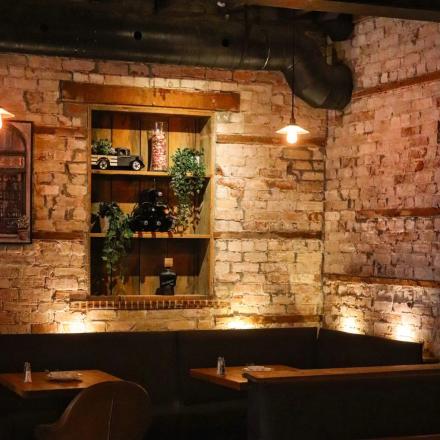 Cozy restaurant booth with exposed brick and decorative wooden shelves