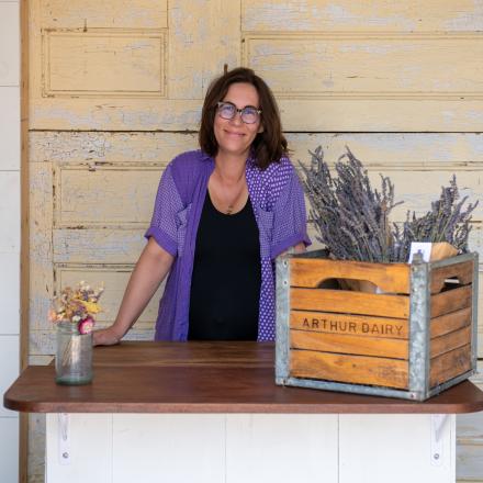 Business owner standing at a counter with a create full of lavender