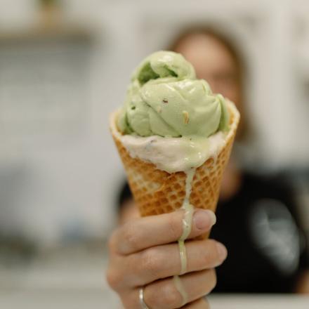 hand holding waffle cone filled with ice cream
