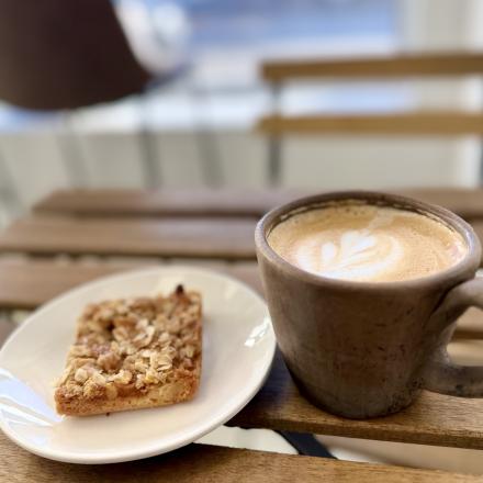 close up of baked square and coffee inside a cafe