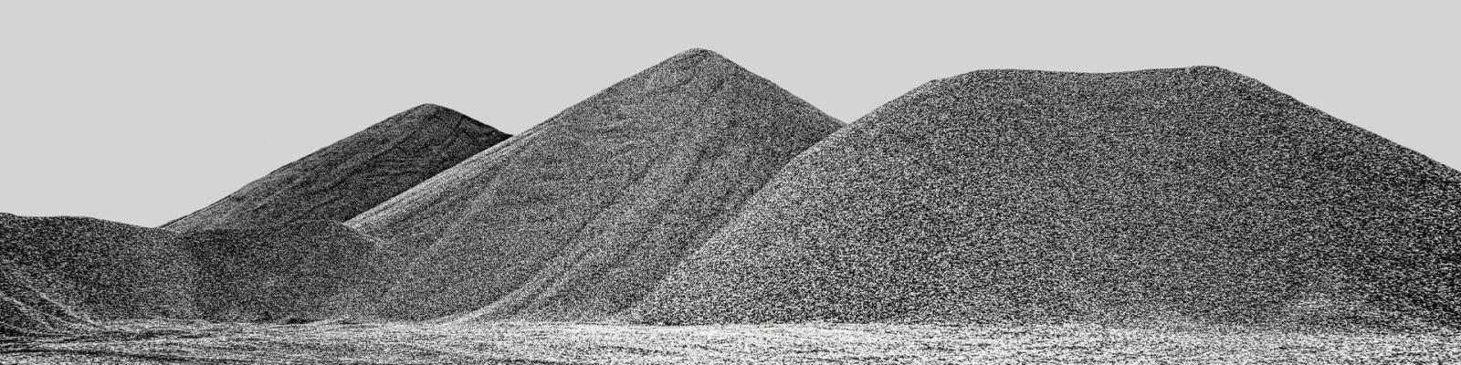 black and white landscape of large mounds of gravel