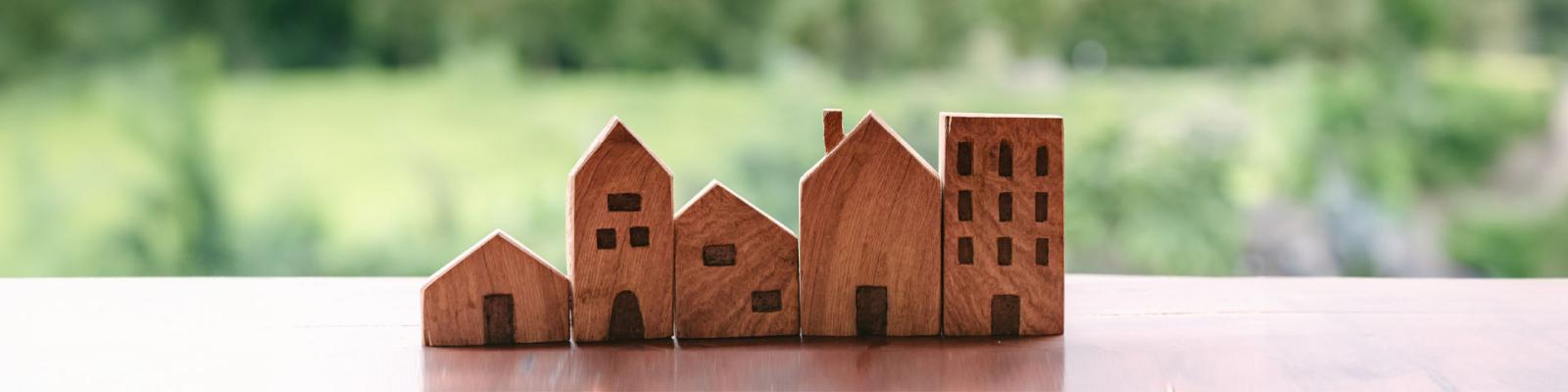 Row of miniature wooden houses lined up on a windowsil