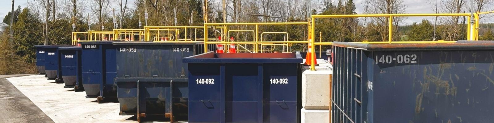 a row of roll off bins at a Wellington County waste facility