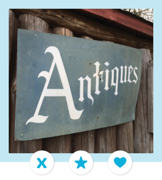 A vintage metal sign reads "Antiques" in old timey type