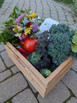 wooden crate full of produce and flowers for a CSA farm share programme