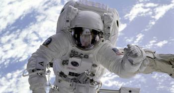 astronaut completing a space walk with earth behind them.