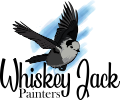 Illustration of a small black, gray, and white bird in mid-flight with wings spread wide. The bird has a white face, dark cap, and soft gray body, resembling a Canada jay. Behind it is a stylized blue paintbrush stroke that suggests motion or sky, set against a white background. Below this is the company name in a cursive like font 'Whiskey Jack" and then in normal font underneath that it says 'Painters'