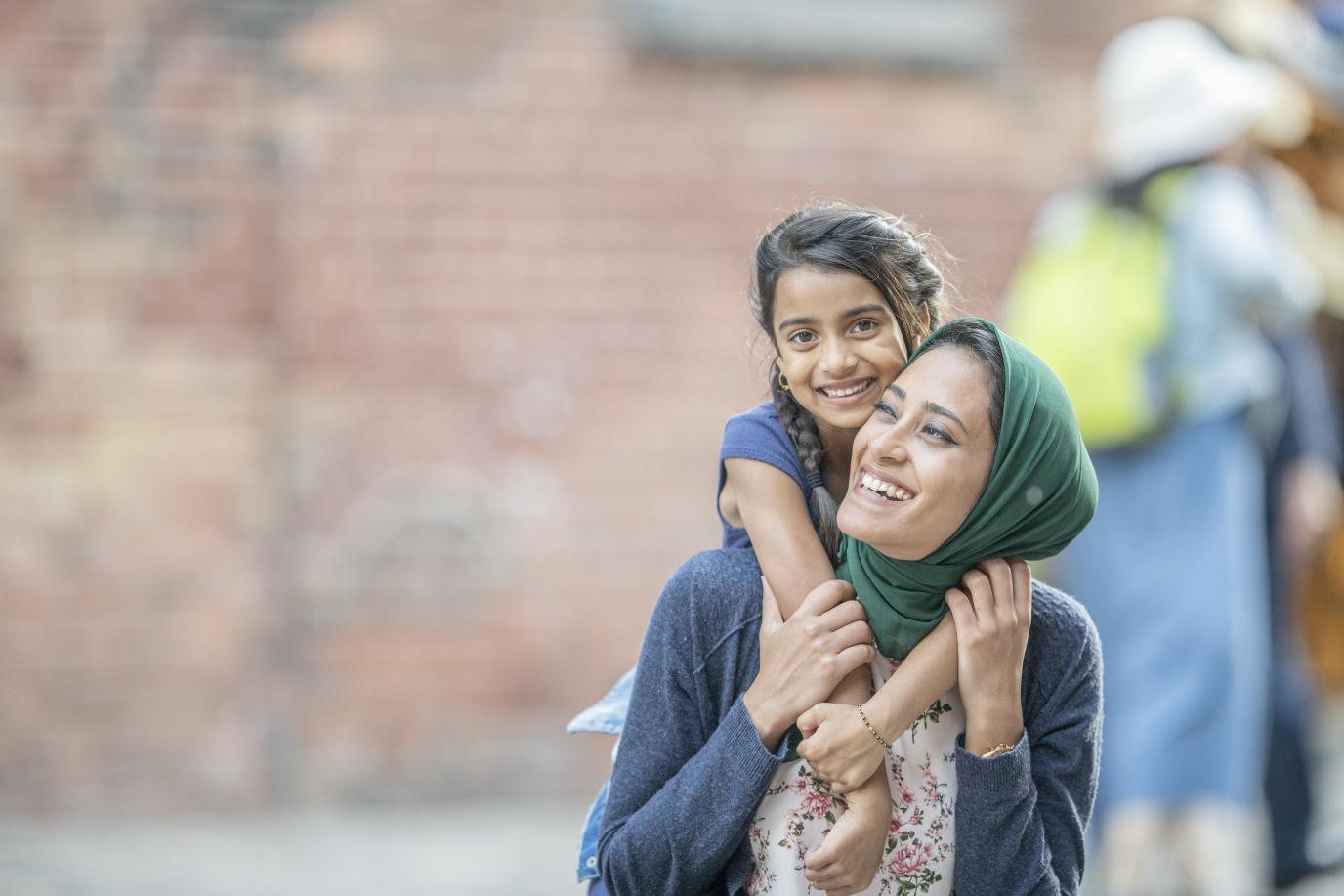 Mother and Daughter hugging and smiling