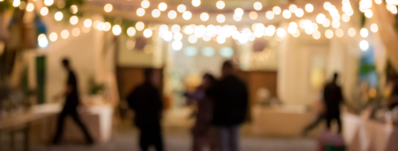 People walking around under fairy lights