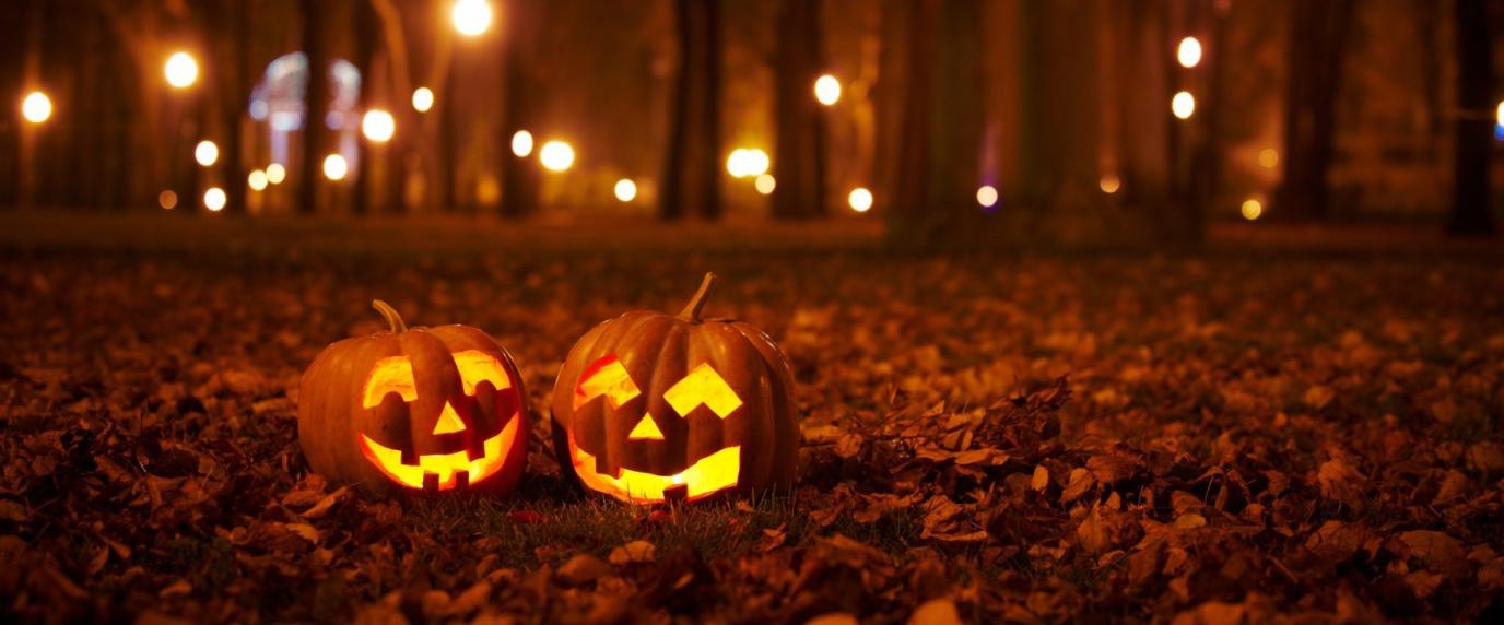 two jack-o-lantern pumpkins sitting on leaves