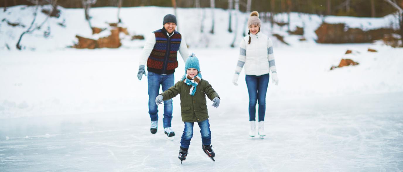 three people skating on ice