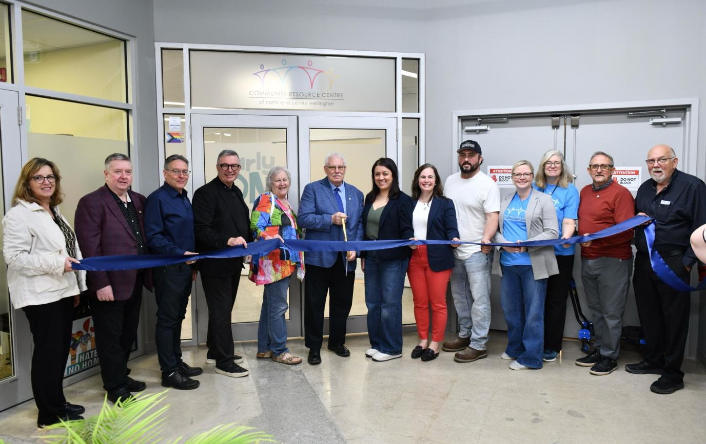 A group of people cutting a ribbon