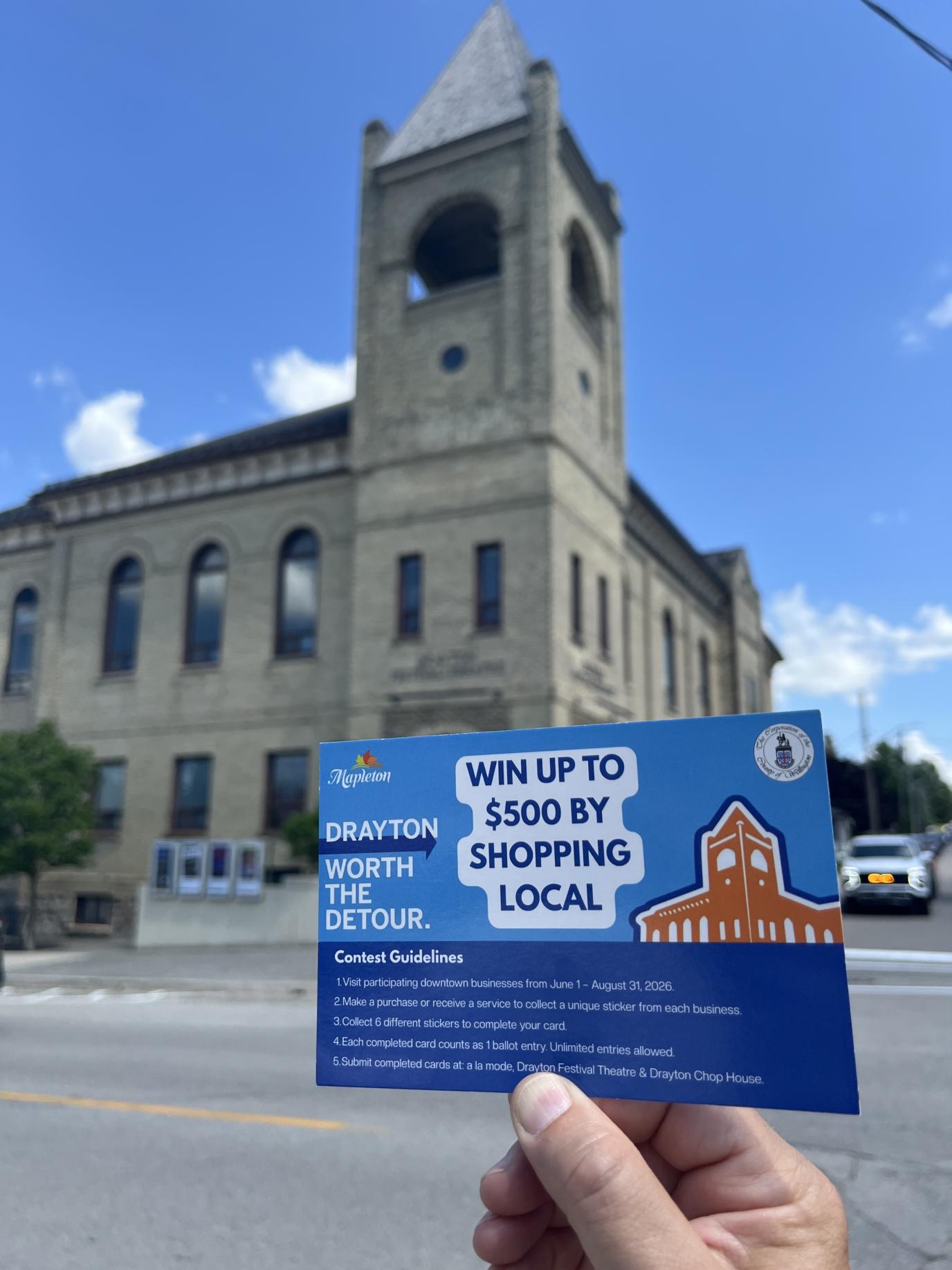 Contest postcard held in front of the Drayton Theatre