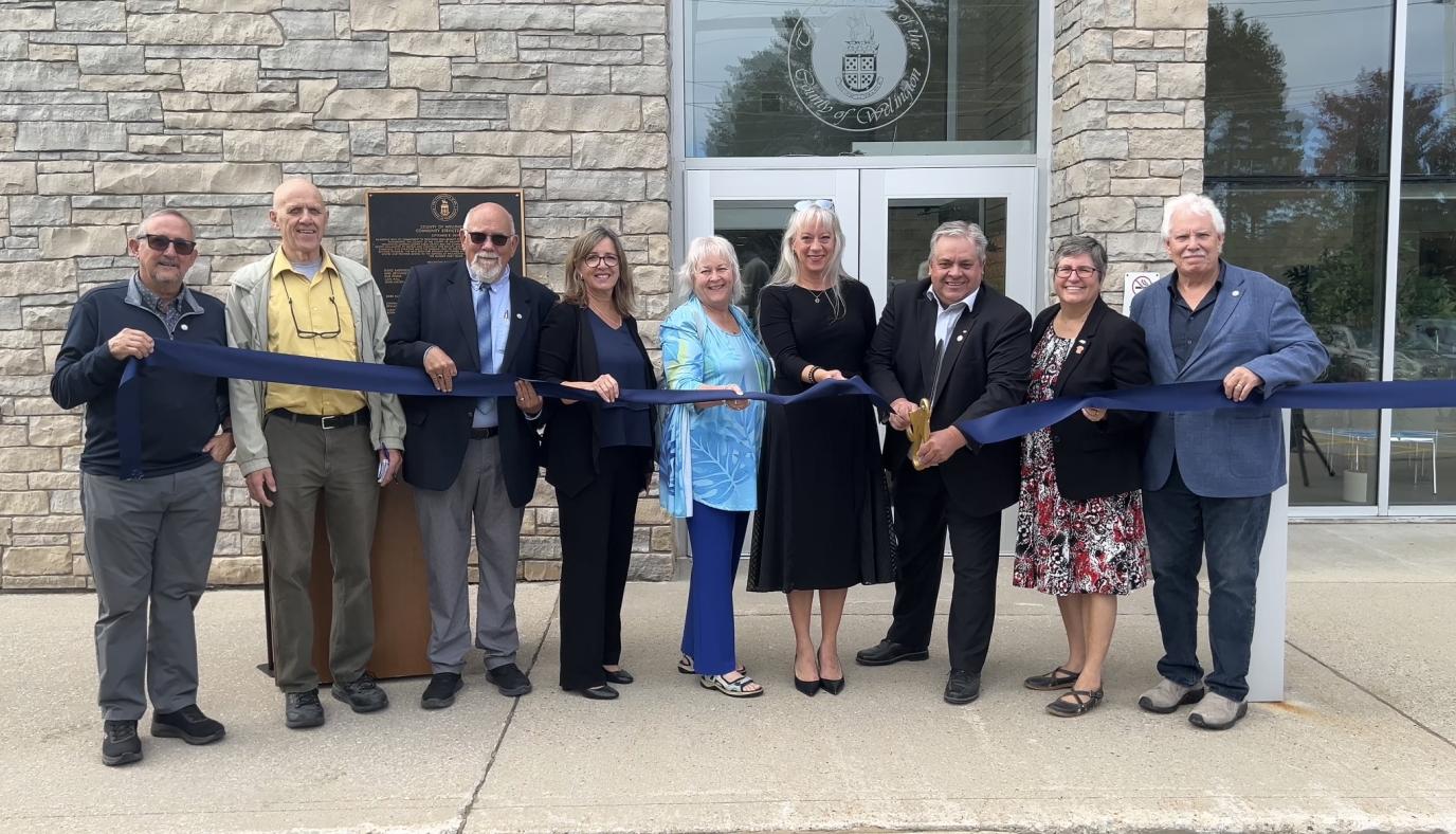 A group of councillors in front of the Wellington North Social Services Office cutting a ribbon.